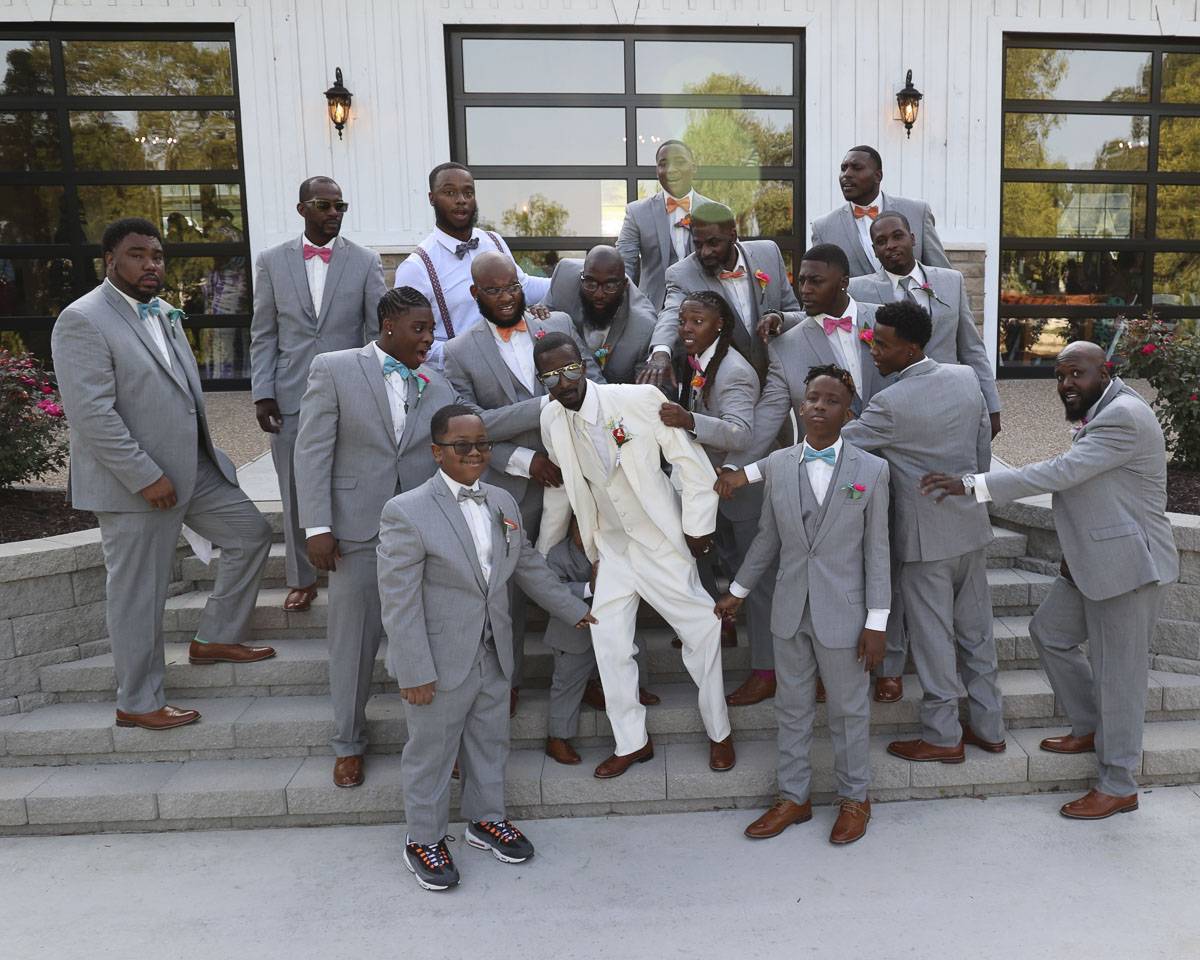 The groomsmen reaching out to the groom