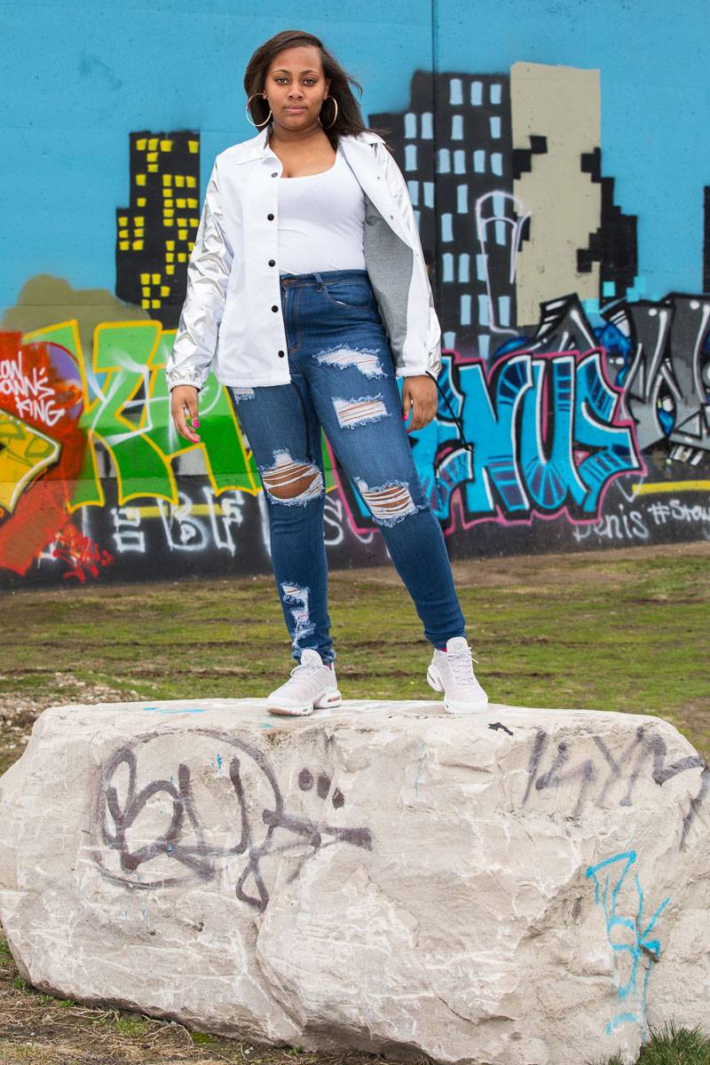 A woman standing on a rock with graffiti