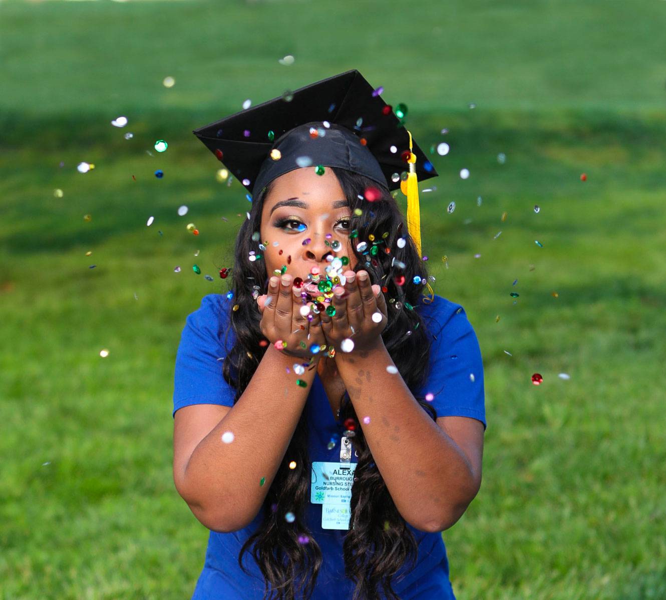 A newly graduate blowing confetti