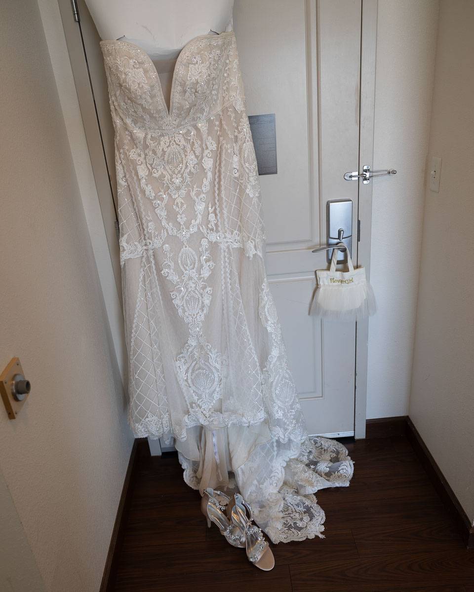 The bride’s wedding dress hanging at the door