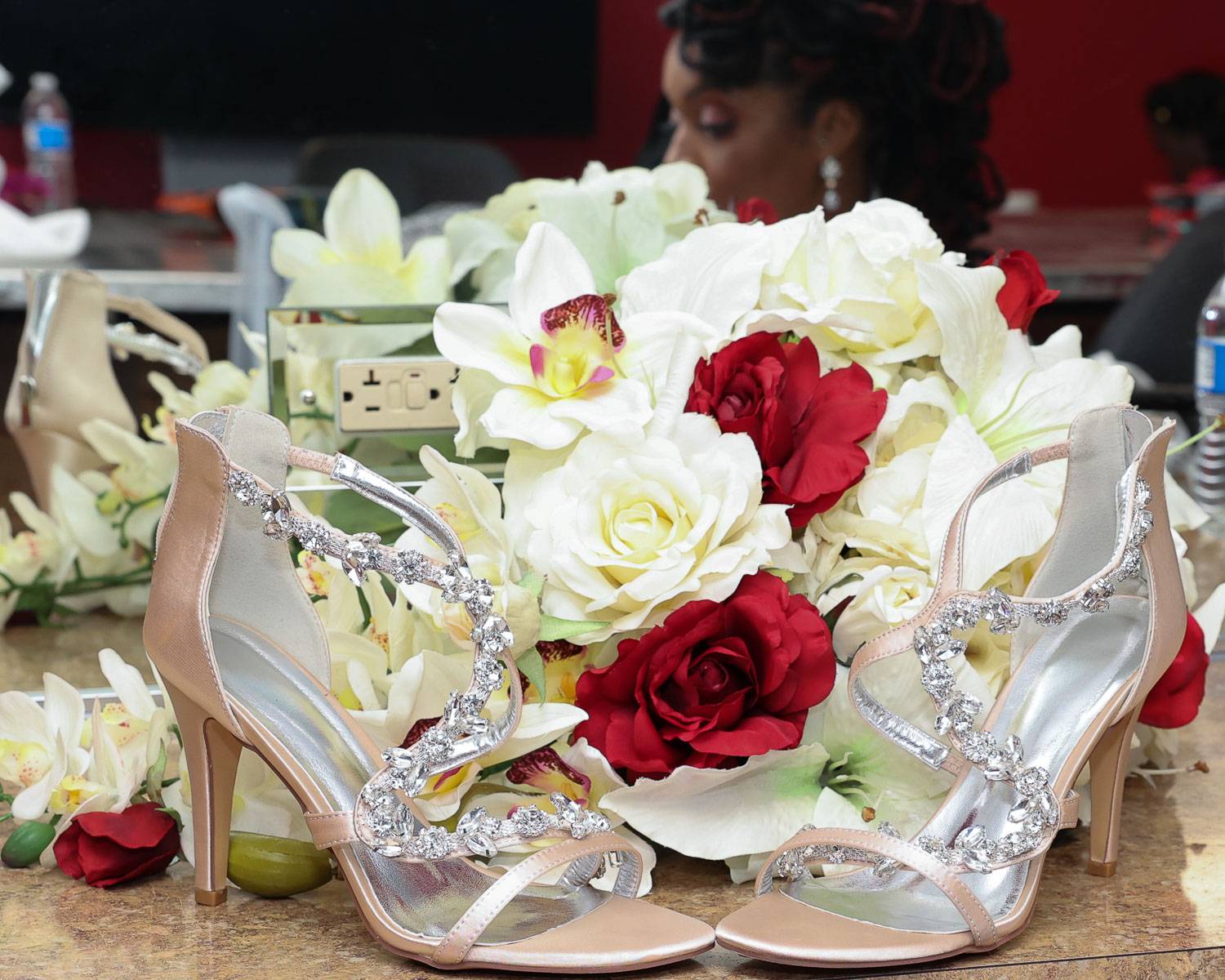The bride’s jeweled slippers and flower bouquet