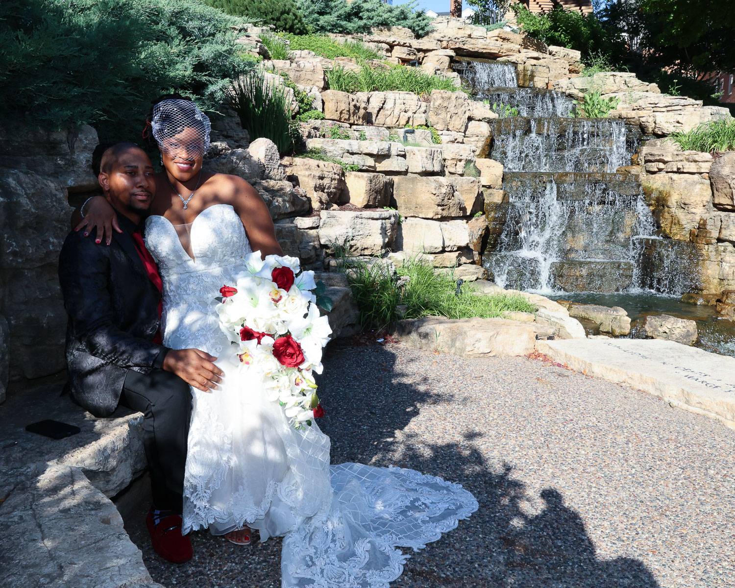The newlyweds sitting near a waterfall