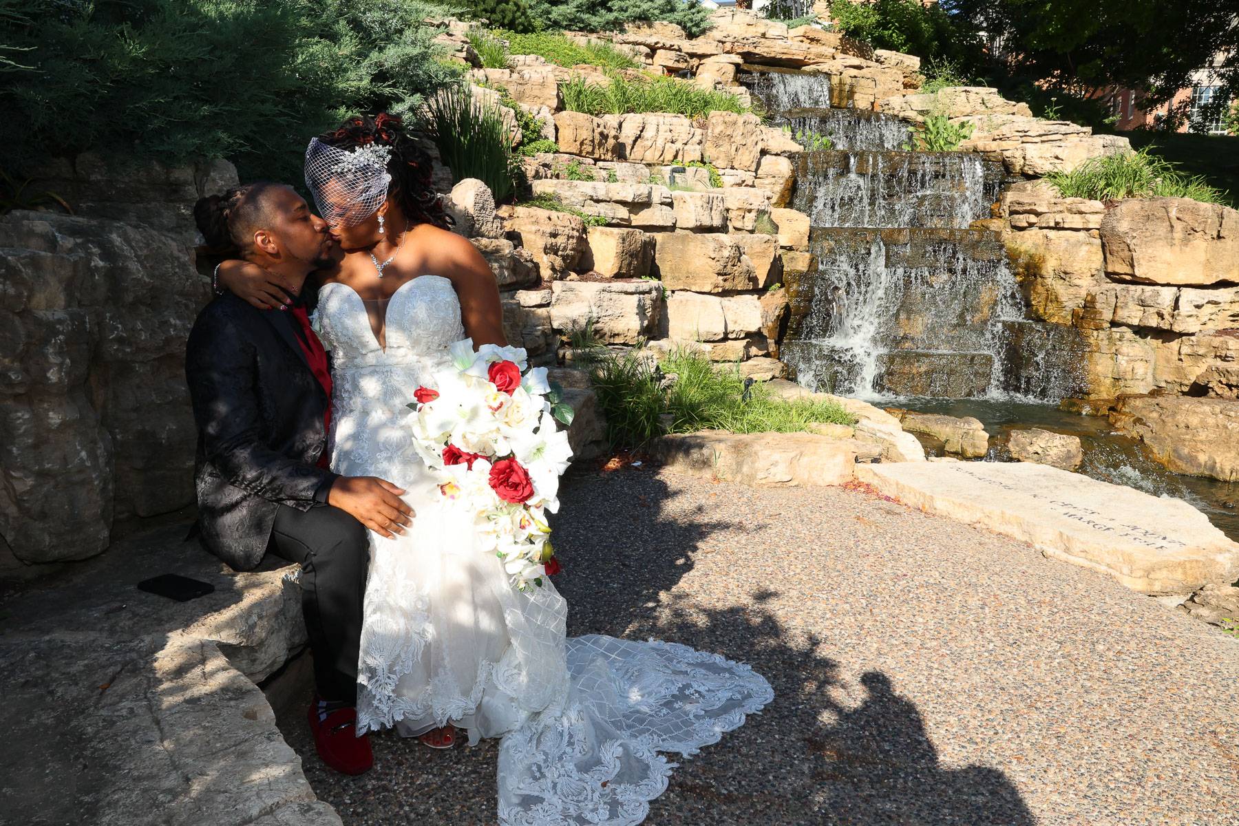 The newlyweds kiss near a waterfall