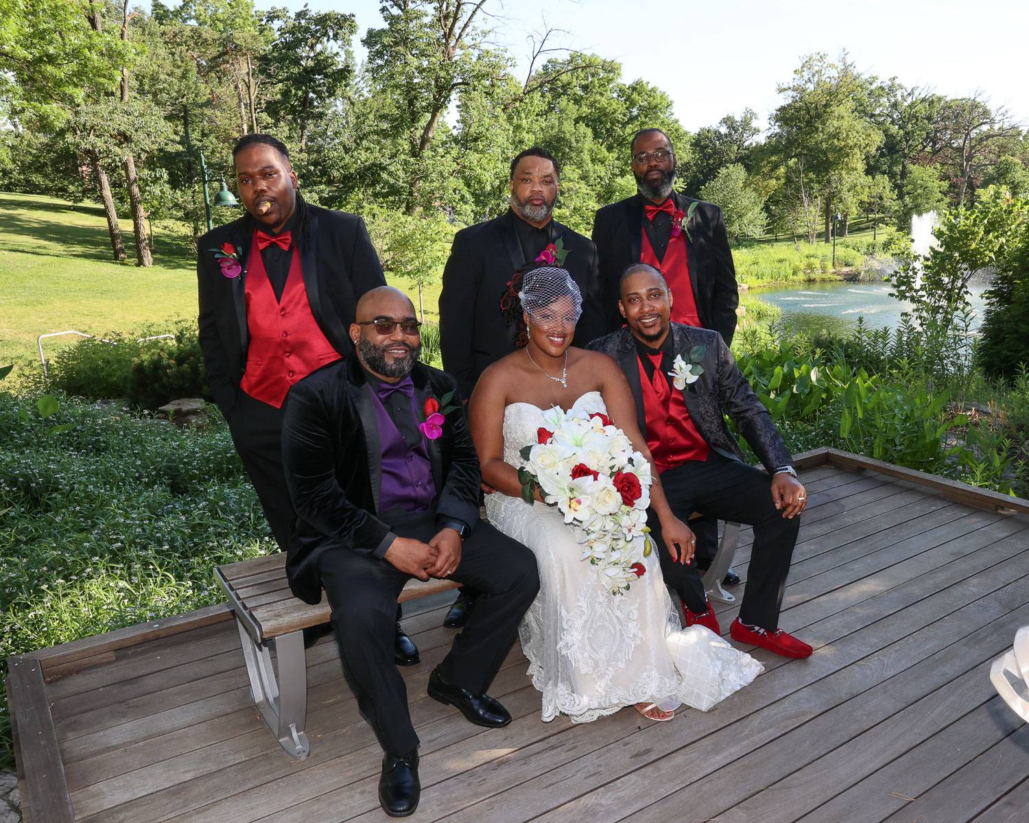 The newlyweds with the groomsmen in the garden