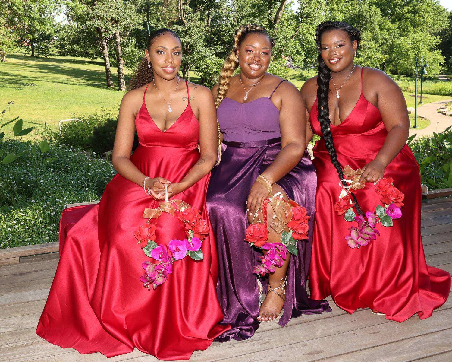 Three of the bride’s attendants in red and purple