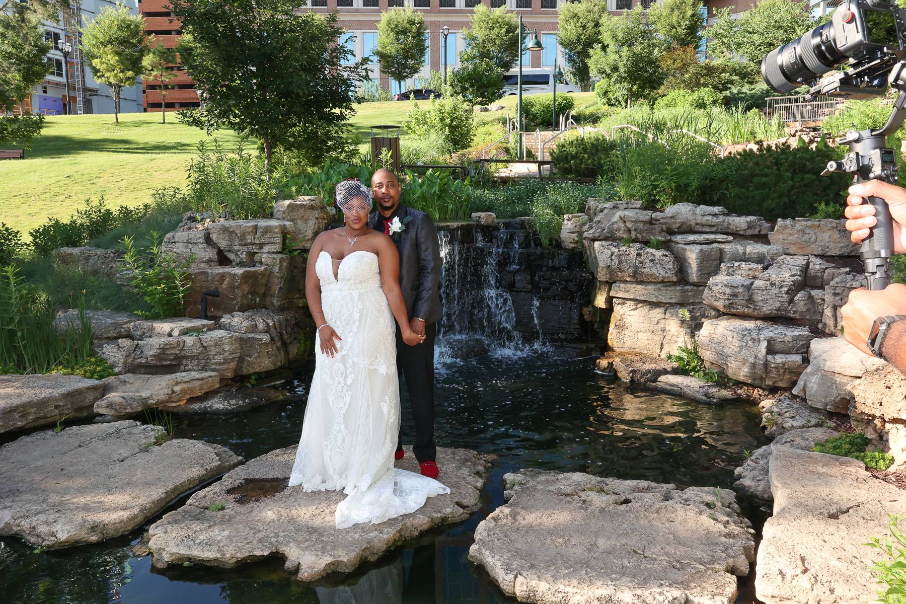 The newlyweds standing by a pond
