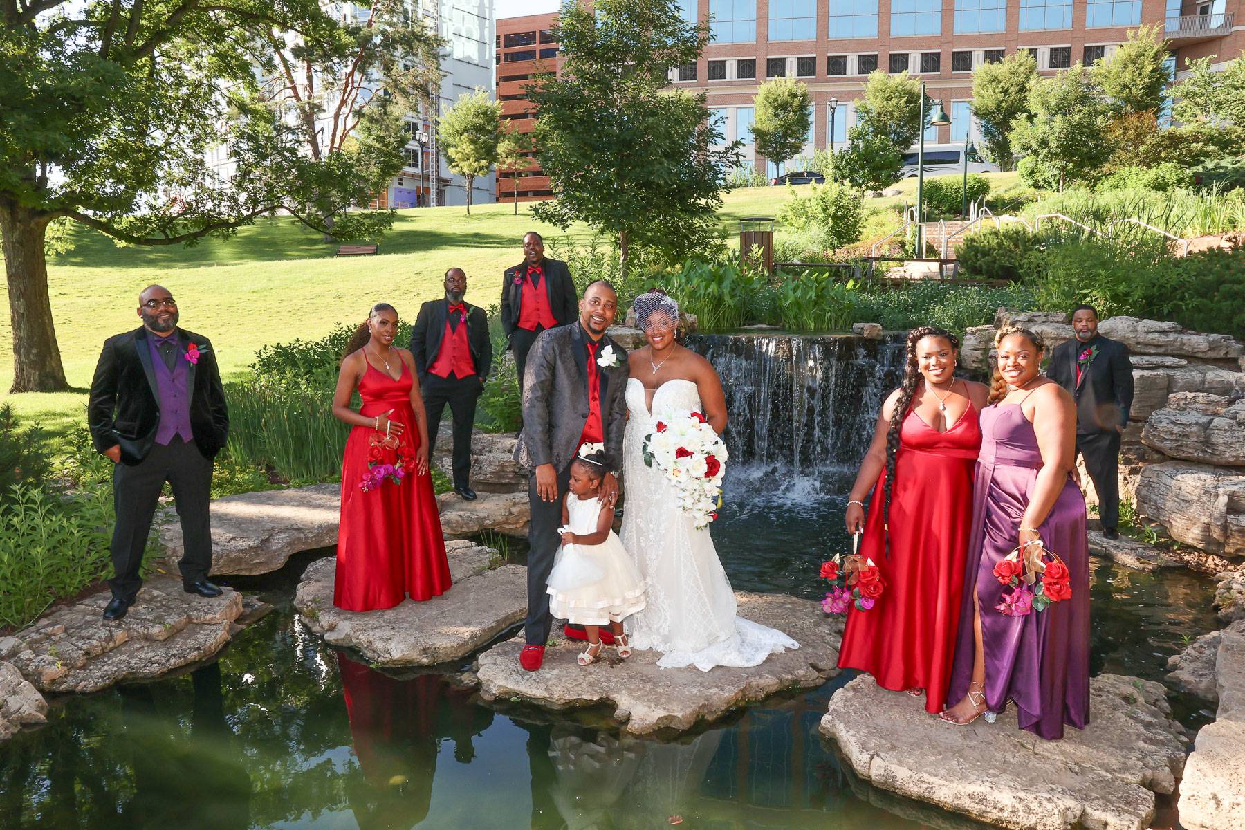 The newlyweds and their attendants surround a pond