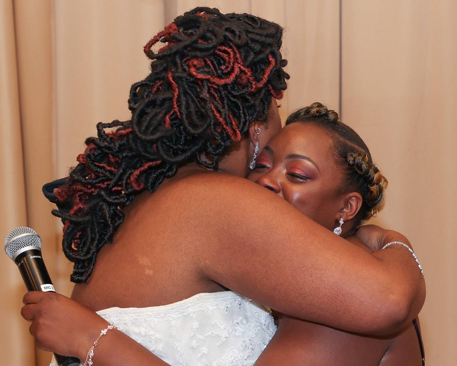 The bride and her friend crying tears of joy