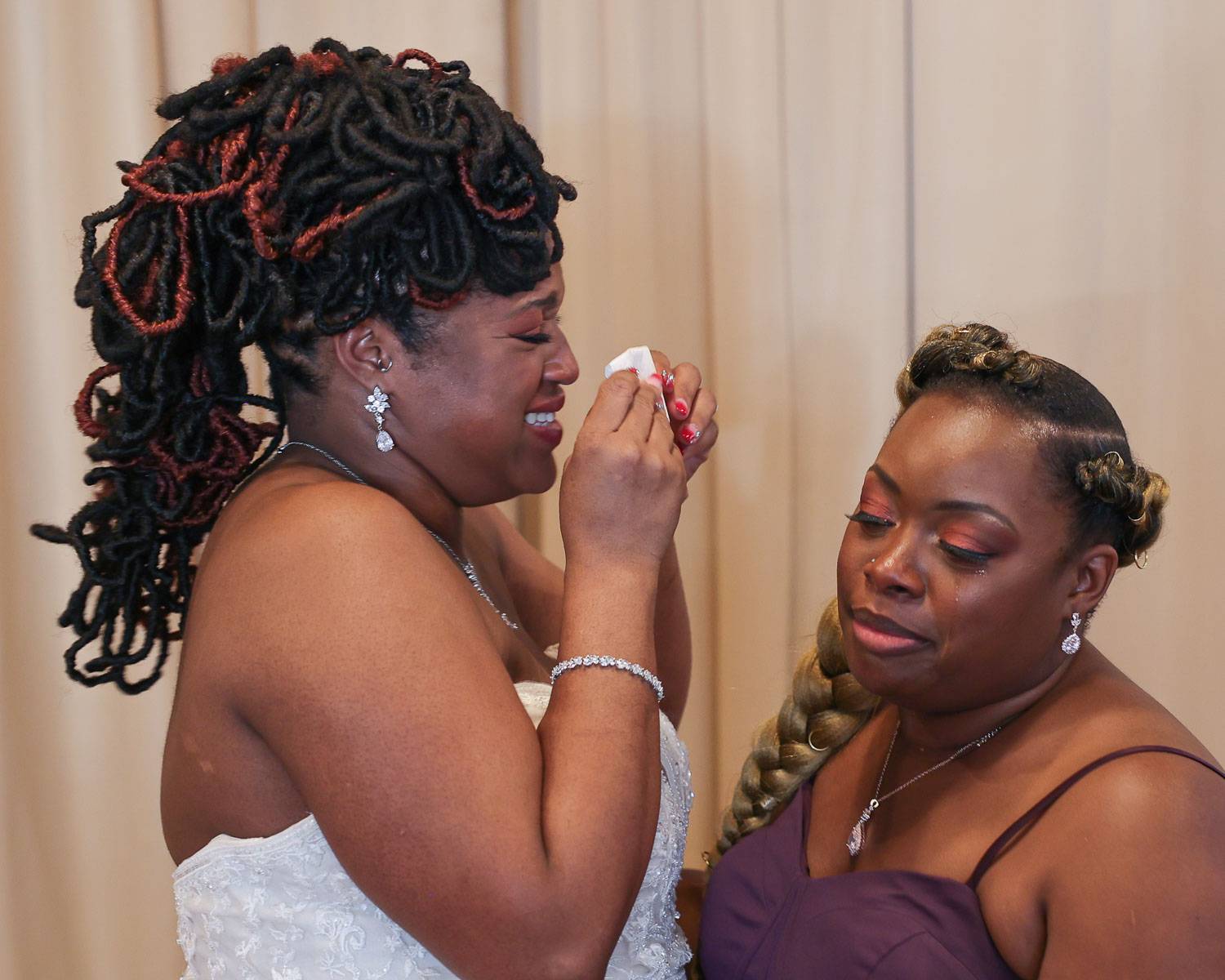 The bride wiping her tears while smiling