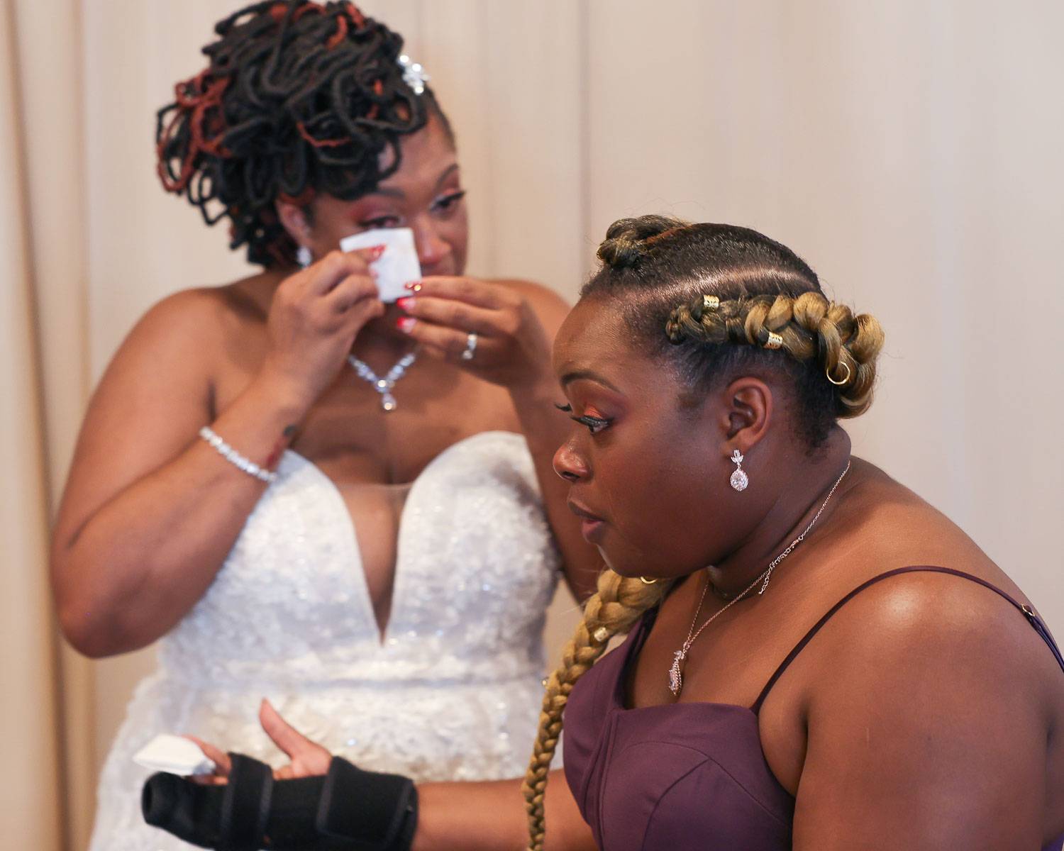The bride wiping her tears with tissue