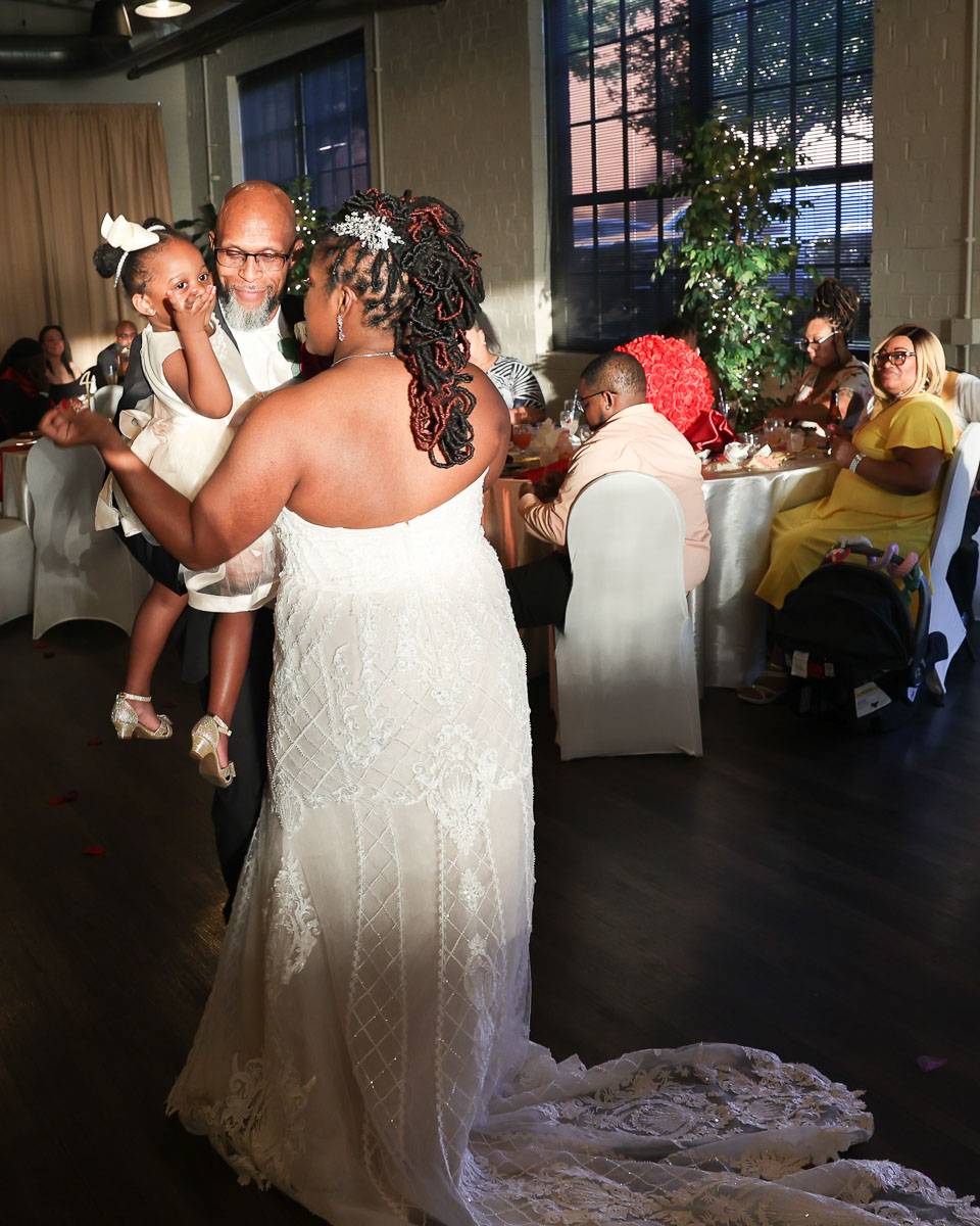 The bride and her father dancing with the toddler