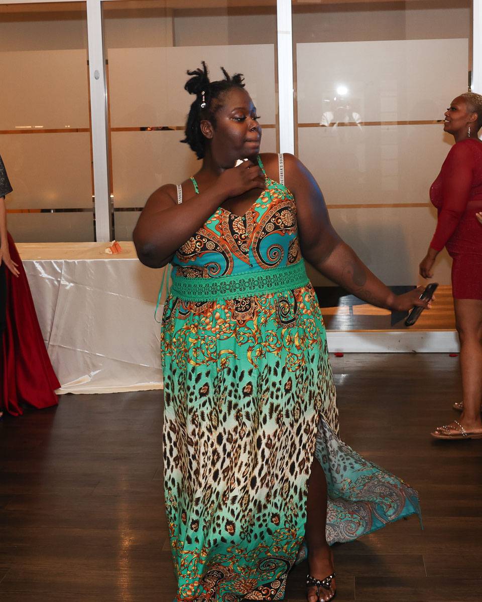 A woman in a patterned teal dress dancing