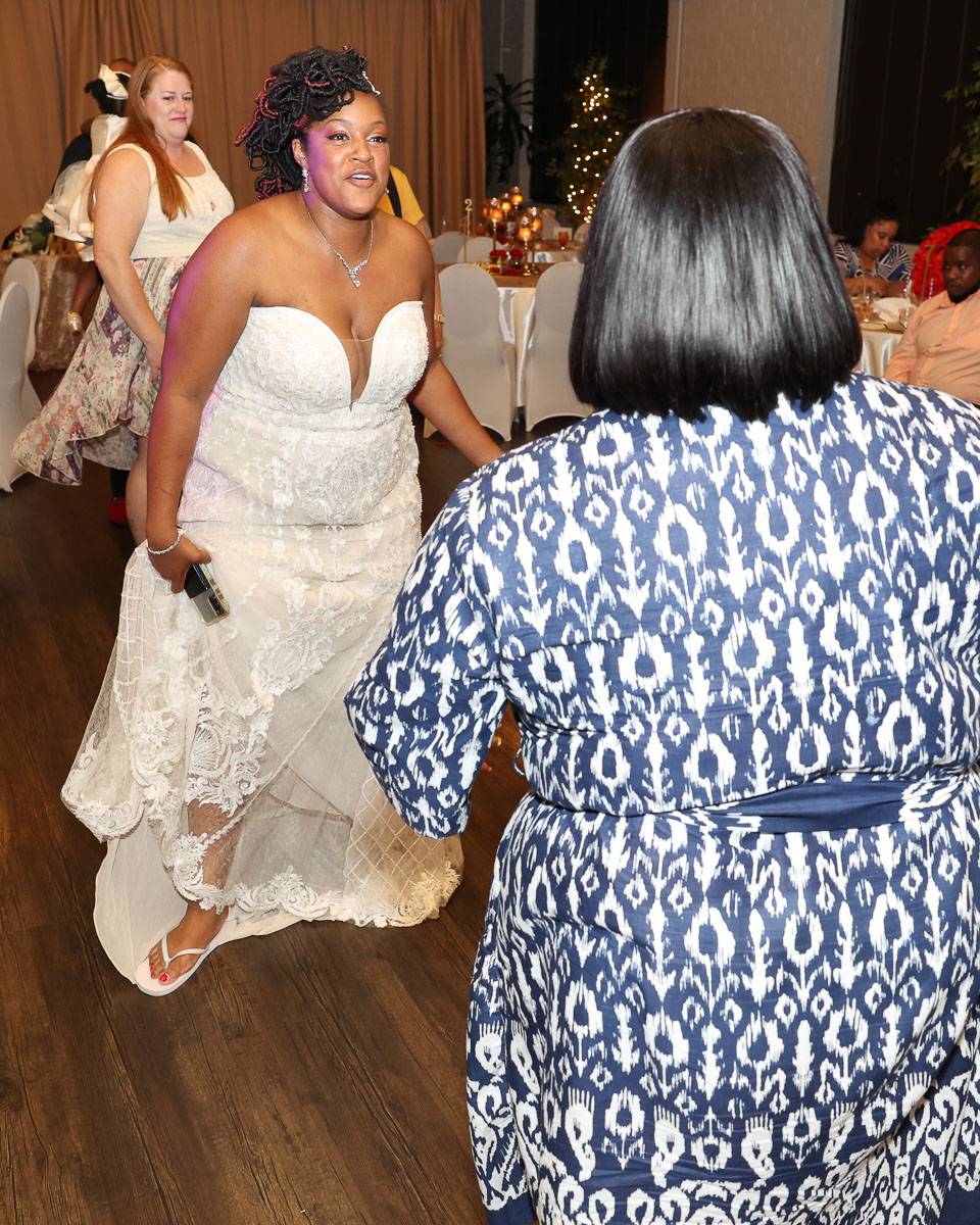 The bride dancing happily while talking to a woman